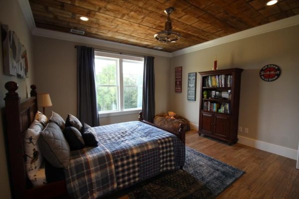 A spacious boys bedroom with special wood ceiling
