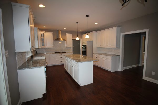 This kitchen features gas cooktop, hood & large island