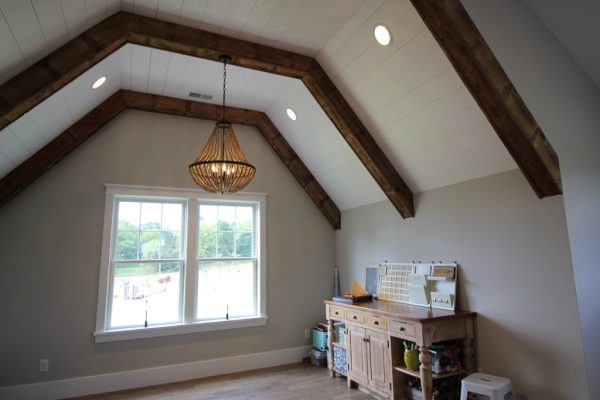 Wood beams, plenty of natural light and a high ceiling make this a great hobby room